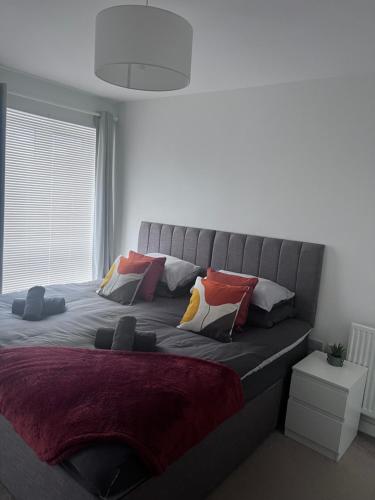 een bed met kussens in een slaapkamer bij The Coach House in Welwyn Garden City