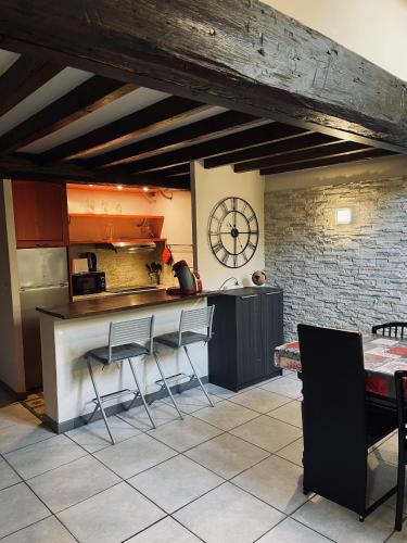 une cuisine avec un comptoir et une horloge au mur dans l'établissement appartement duplex a deux pas du port, à Cannes