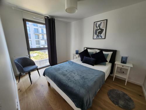 une chambre avec un lit, une chaise et une fenêtre dans l'établissement Le Quai des Bleus, à Caen