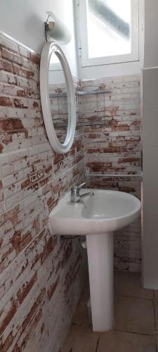 La salle de bains est pourvue d'un lavabo blanc et d'un miroir. dans l'établissement Casita cerca del mar, à Playa de Gandia