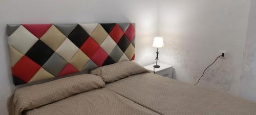 - une chambre avec un lit doté d'une tête de lit colorée dans l'établissement Casita cerca del mar, à Playa de Gandia
