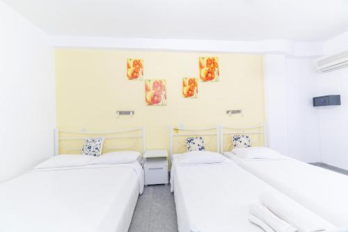 two beds in a room with white walls at George Studios in Naxos Chora