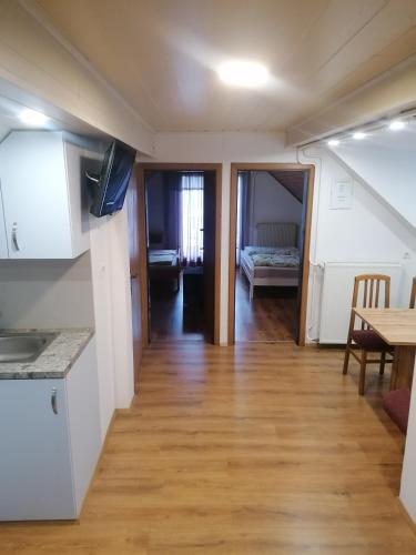 a kitchen and a living room with a wooden floor at Apartments Gubanec in Cerklje na Gorenjskem
