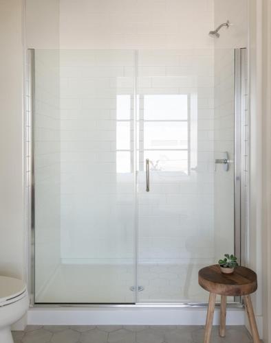 a shower with a glass door in a bathroom at Roost Baltimore in Baltimore