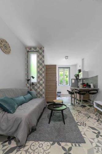 un salon avec un canapé, une table et un bureau dans l'établissement Le Gacon - Appartement centre ville, à Vichy