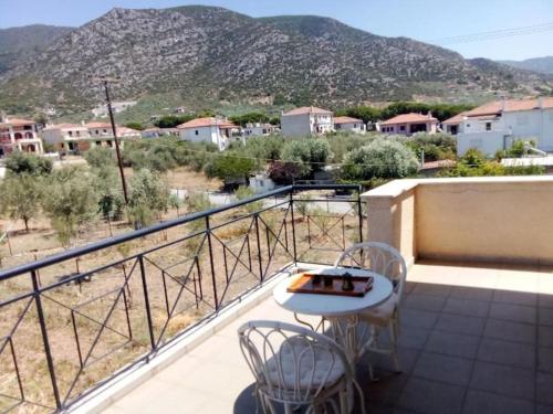 a balcony with a table and chairs and a mountain at The A project, Deluxe Suites in Agria