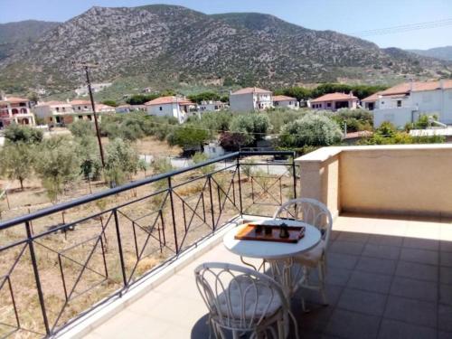 a balcony with a table and chairs and a mountain at The A project, Deluxe Suites in Agria
