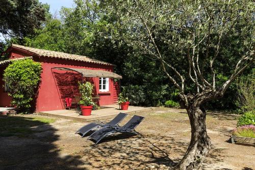 un par de sillas frente a una casa roja en Les Gîtes du Domaine de Rhodes, en Aviñón