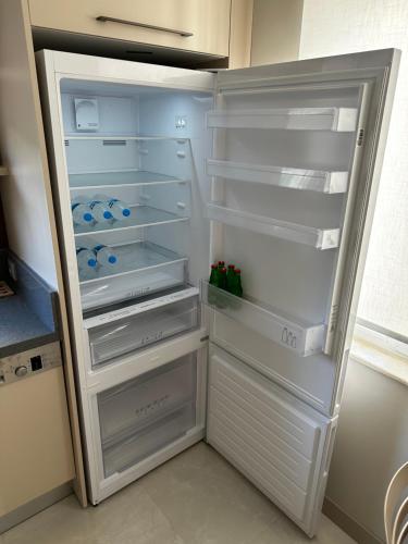 an empty refrigerator with its door open in a kitchen at Side Holiday House in Side