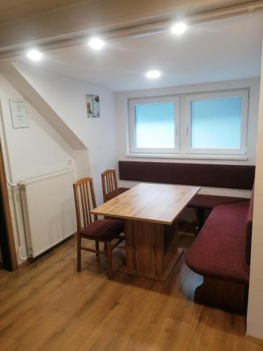 a dining room with a wooden table and chairs at Apartments Gubanec in Cerklje na Gorenjskem