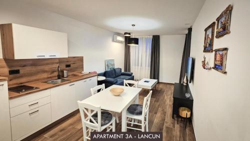 een keuken en een woonkamer met een witte tafel en stoelen bij Casa Mili Jezera in Jezera