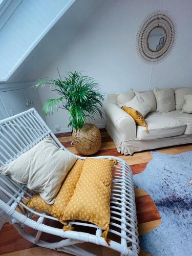 a white rattan bed in a living room with a couch at Le St Pier, T3 en centre ville proche Gare in Vannes