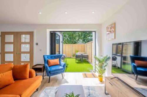 a living room with a couch and blue chairs at The Old School Sleeps 14 in Lymington