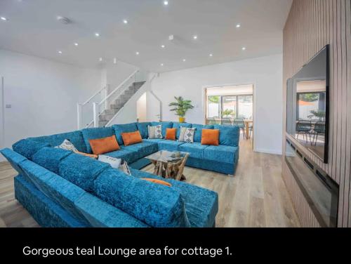 a living room with a blue couch and a table at The Old School Sleeps 14 in Lymington
