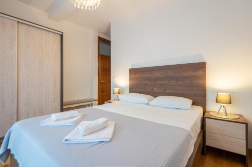 a bedroom with a large white bed with towels on it at White Hill Villa in Masline