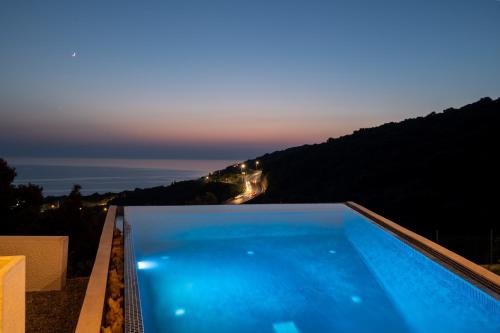 a swimming pool with a view of the ocean at White Hill Villa in Masline