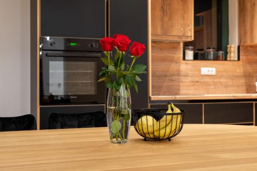 a vase of roses and a bowl of bananas on a table at White Hill Villa in Masline