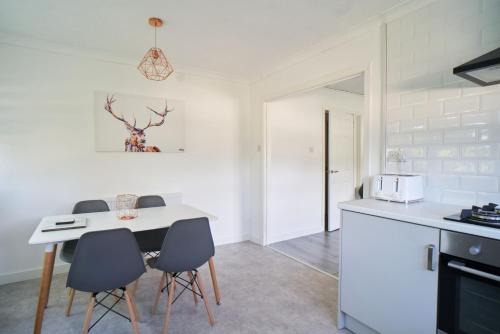 a kitchen with a table and chairs in a room at Woodside Apartment in Coatbridge