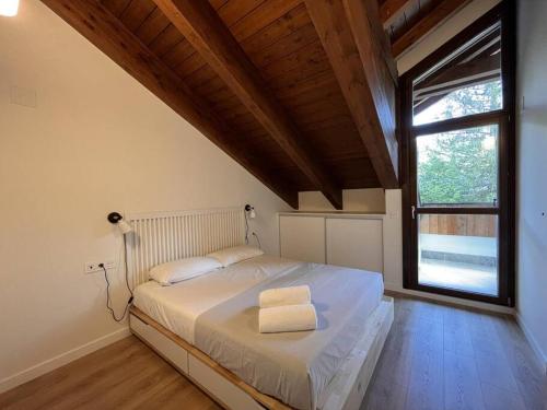 1 dormitorio con 1 cama blanca grande y ventana en BPIRINEOS- Aire Pirineos, en Benasque