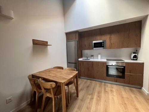 cocina con mesa de madera y sillas en una habitación en BPIRINEOS- Aire Pirineos, en Benasque