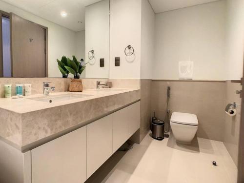 La salle de bains est pourvue d'un lavabo, de toilettes et d'un miroir. dans l'établissement Key View - Act One Act Two, Downtown Dubai, à Dubaï
