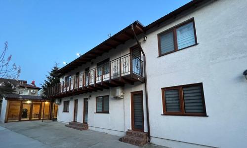 ein weißes Haus mit einem Balkon an der Seite in der Unterkunft Casa TIBI și Nico in Eforie Nord