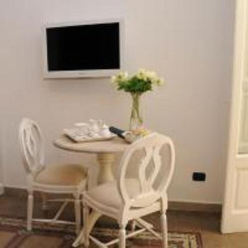 a table with two chairs and a vase with flowers on it at Casa Blanca in Reggio Calabria