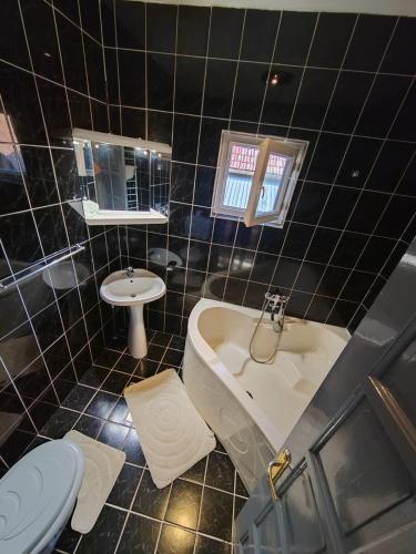 een badkamer met een bad, een toilet en een wastafel bij LaSovataa in Sovata