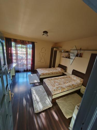 three beds in a room with wooden floors at LaSovataa in Sovata
