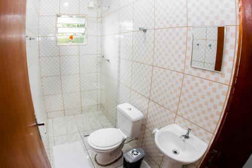 uma casa de banho com um WC e um lavatório em CASA DA ZEZÉ Pousada & Hotel ITABORAÍ em Itaboraí