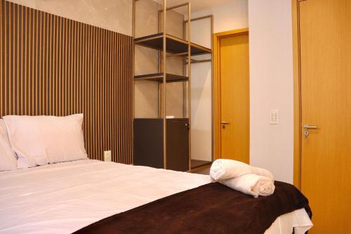 a bedroom with a bed and a book shelf at Buenos Ayres por Carpediem in Tambaú