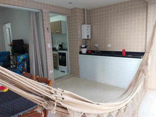 a hammock in a room with a kitchen at Lindo Apartamento na Praia do Sonho in Itanhaém