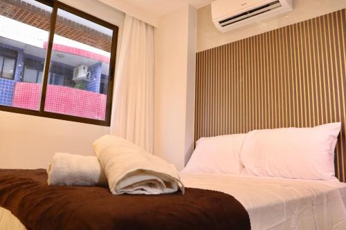 a bedroom with a bed with a window at Buenos Ayres por Carpediem in Tambaú