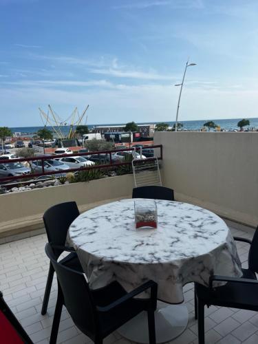 una mesa en un balcón con vistas al puerto deportivo en RAINIE APPART en Palavas-les-Flots