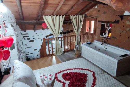 a bedroom with a bath tub and a large bed with roses at Casa rural La calleja de las hurdes TRCC00555 in Sauceda