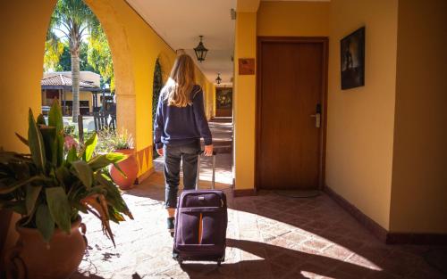 a woman walking down a hallway with a suitcase at Hacienda Don Justo Hotel Boutique Spa in Colón