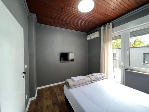 a bedroom with a white bed and a tv at Lux apartments Crystal-center in Bihać