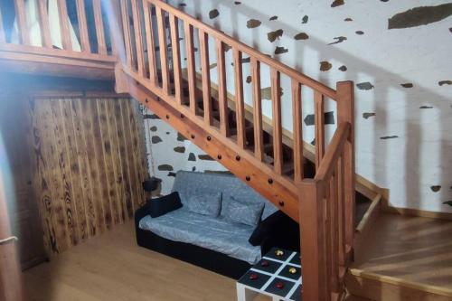 a wooden staircase with a blue couch under it at Casa rural La calleja de las hurdes TRCC00555 in Sauceda