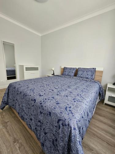 a bedroom with a bed with a blue comforter at Residencias Ana Carmen in Viana do Castelo