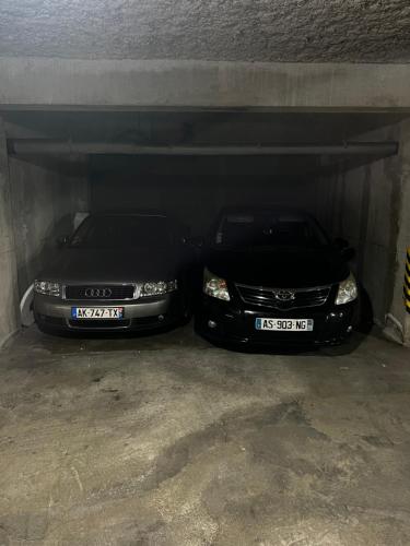 dos coches están aparcados bajo un garaje en RAINIE APPART en Palavas-les-Flots