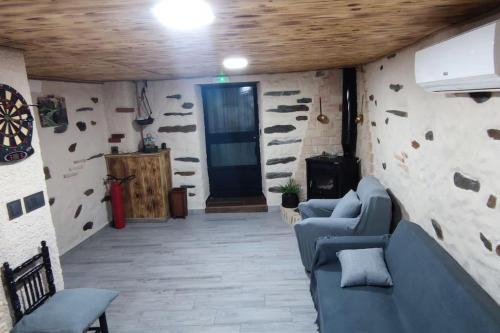 a living room with a blue couch and a wooden ceiling at Casa rural La calleja de las hurdes TRCC00555 in Sauceda