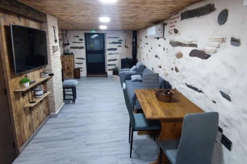 a dining room with chairs and a table and a tv at Casa rural La calleja de las hurdes TRCC00555 in Sauceda