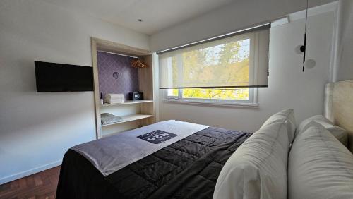 1 dormitorio con cama, ventana y sofá en HotelN26 en Mar del Plata