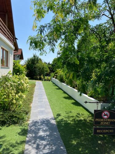 a walkway in a yard next to a house at Ida Rooms in Lajosmizse