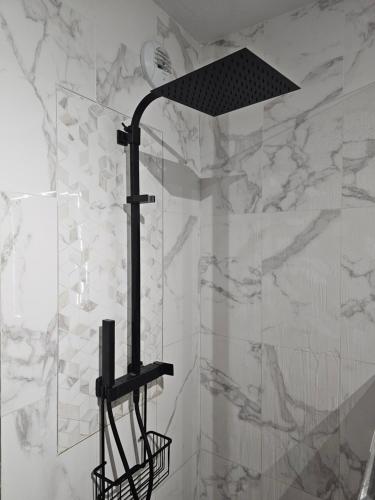 a shower with a black shower head in a bathroom at Cosy T2 entre terre et mer in Montpellier