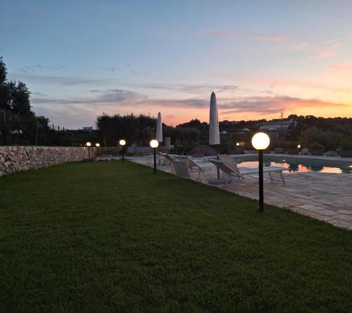 a row of lights on the grass near a pool at Quattroperle Trulli - Relax - Puglia in Castellana Grotte