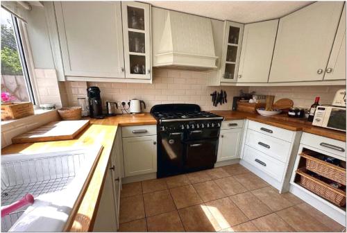 een keuken met witte kasten en een zwarte kachel bij Luxury apartment Old Compton St in Londen
