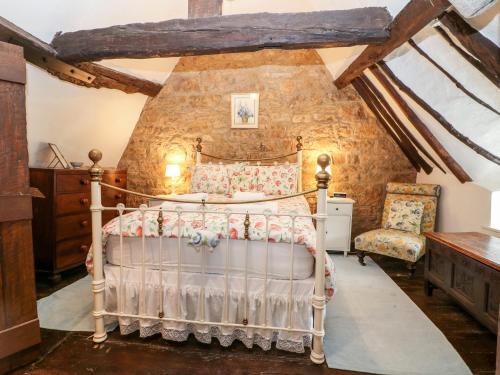 a bedroom with a wooden bed in a room at Thatched Cottage in Chipping Campden