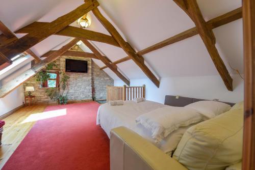 a attic bedroom with two beds and a tv at Haye Barton Farm in Liskeard
