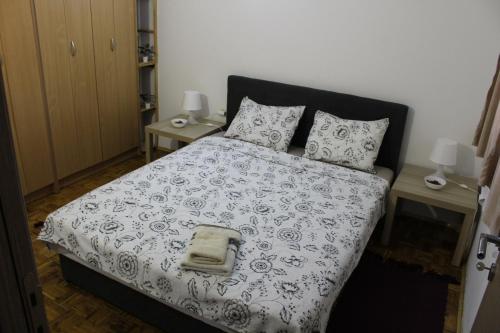 Cama con manta y almohadas blancas y negras en Apartman AS, en Belgrado